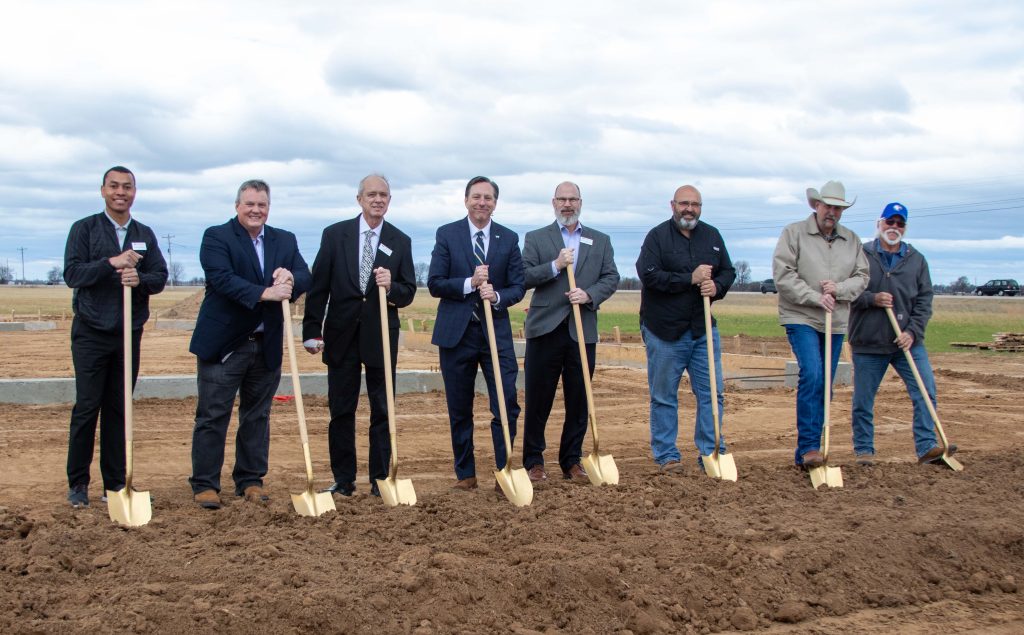 WBU Board of Trustees and President "breaking ground" on meat processing facility by digging in the soil with gold shovels