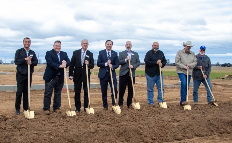 WBU Board of Trustees and President "breaking ground" on meat processing facility by digging in the soil with gold shovels